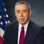 George Abbey headshot in front of American flag